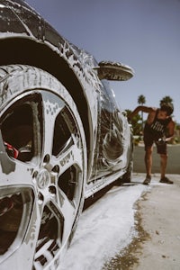 a man washing his car with soap and water